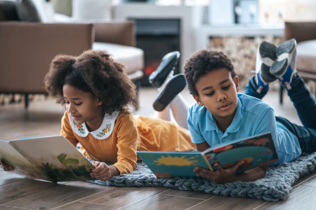 duas crianças lendo livros de historias infantis